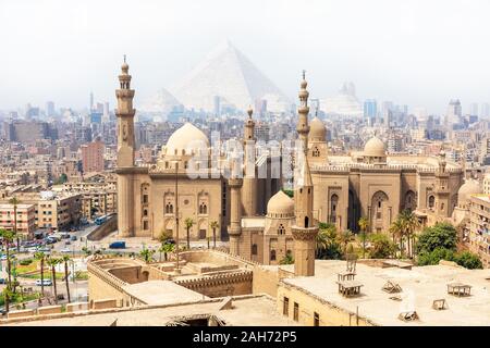 Mosque-Madrassa of Sultan Hassan and the Pyramids in the mist, Cairo, Egypt Stock Photo