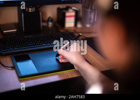 A person using graphic tablet with pen and working on new project idea Stock Photo