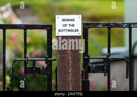 Symmetrical close up of a sign on a wooden fence warning against the dog Stock Photo
