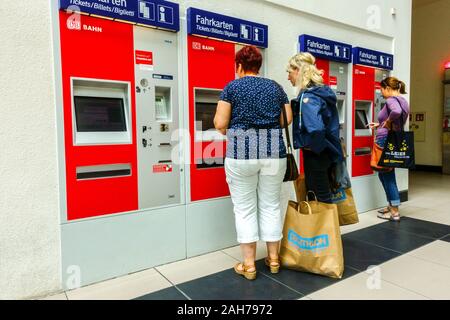 German women with shopping bags buy tickets in Self-service ticket machines, DB, Deutsche Bahn Dresden Station  Germany Stock Photo
