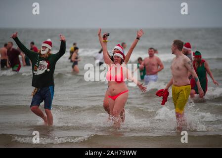 Tynemouth, England, 26 December 2019. Participants leaving the North Sea during the Boxing Day Dip which is an annual event organised by the North Sea Volunteer Lifeguards on the Longsands Tynemouth. Stock Photo