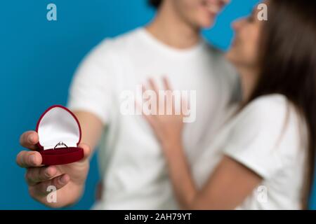 Cropped view of couple with proposal ring isolated on blue background. Stock Photo