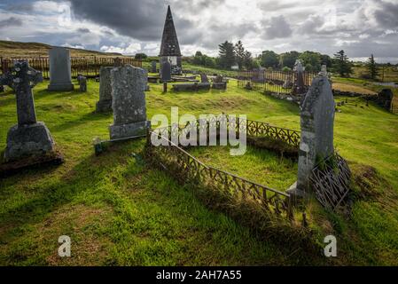 An ancient and abandoned scottish cemetery under a cloudy sky in the late afternoon light Stock Photo