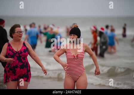 Tynemouth, England, 26 December 2019. Participants leaving the North Sea during the Boxing Day Dip which is an annual event organised by the North Sea Volunteer Lifeguards on the Longsands Tynemouth. Stock Photo