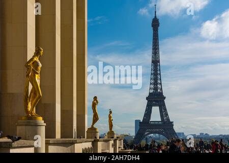 Paris, France - November 8, 2019: Golden sculptures on the busy esplanade of the Chaillot Palace, with the Eiffel Tower in the background Stock Photo