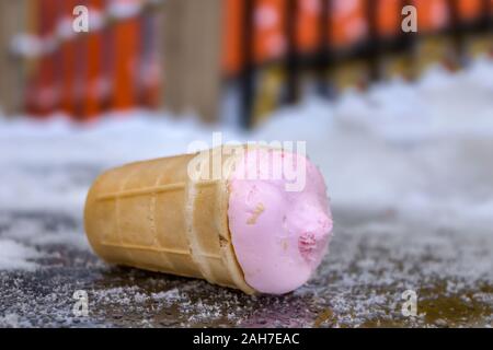 Fallen popsicles lie on a cold snowy surface in a park Stock Photo