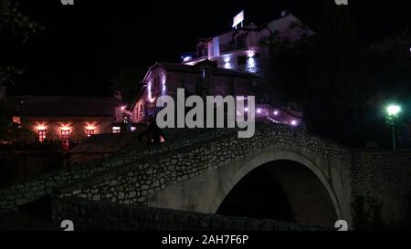 A small stone bridge - Night in old city Mostar, Bosnia and Herzegovina. A view of the Kriva Cuprija/ Crooked Bridge in Mostar at night. Stock Photo