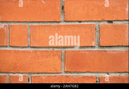 Brick wall texture close-up. Orange yellow masonry macro. Brickwork grunge background. Brick laid crookedly. Stock Photo
