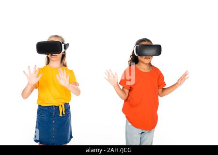 two cute multicultural friends using virtual reality headsets isolated on white Stock Photo