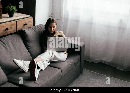 Beautiful girl with prosthetic leg using laptop with blank screen