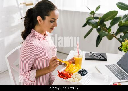 happy girl holding fork near food container with vegetables Stock Photo