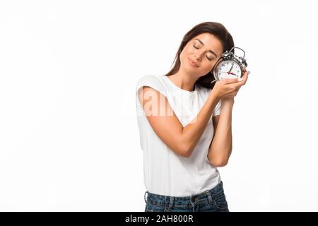 sleepy woman with closed eyes holding alarm clock, isolated on white Stock Photo