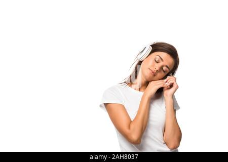 beautiful sleepy woman with closed eyes listening music with headphones, isolated on white Stock Photo