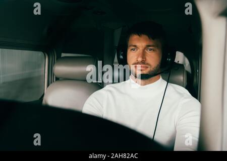 handsome bearded pilot in headset in plane Stock Photo