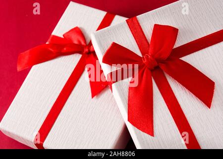 Assorted white gift boxes on red background. Stock Photo
