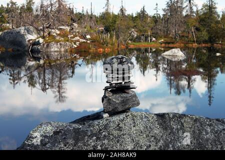 Swamp or lake with megalithic seid boulder stones, dead trees in nature reserve on mountain Vottovaara, Karelia, Russia. Natural background view. Lapp Stock Photo