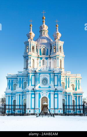 Symmetrical close up shot of a blue and white russian church against a solid blue sky