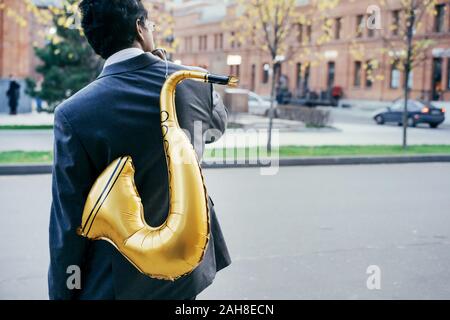 Funny handsome Indian man with a golden color inflatable tube Stock Photo