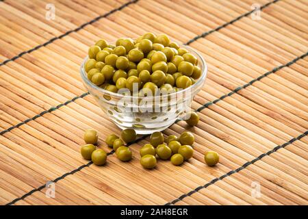 Canned green peas in the bowl on wood background Stock Photo