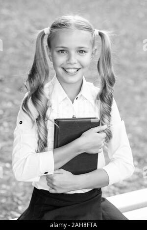 Study language. School education concept. Cute little bookworm. Knowledge day. Ready for lessons. Secondary school student. Cute smiling small child hold book. Adorable little girl school student. Stock Photo