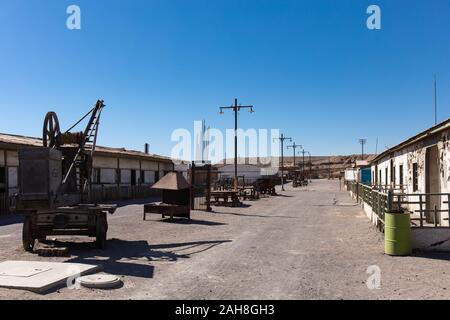 Machinery on display in a street in the residential area of the abandoned Humberstone Saltpeter factory in the Atacama Desert, Northern Chile Stock Photo