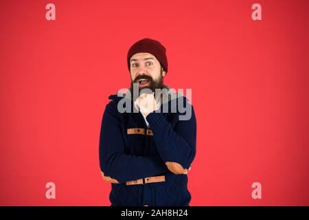 Think and decide. Winter menswear. Man bearded warm jumper and hat red background. Winter season menswear. Personal stylist. Warm and comfortable. Fashion menswear shop. Masculine clothes concept. Stock Photo