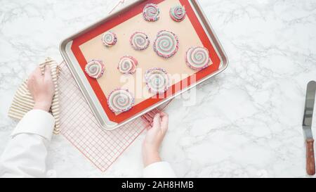 Step by step. Flat lay. Cooling freshly baked bake red, white, and blue pinwheel sugar cookies on a cooling rack. Stock Photo