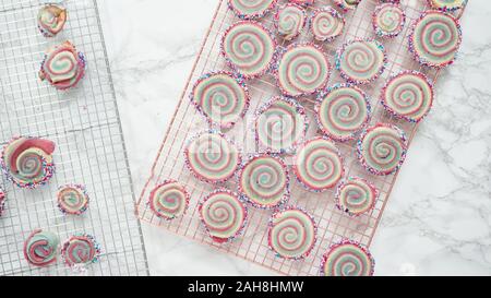 Step by step. Flat lay. Cooling freshly baked bake red, white, and blue pinwheel sugar cookies on a cooling rack. Stock Photo