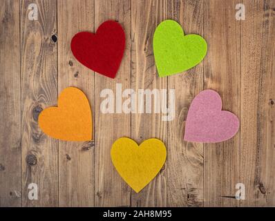 coloured hearts forming a circle on a walnut wood background. Concept of St. Valentine's Day Stock Photo