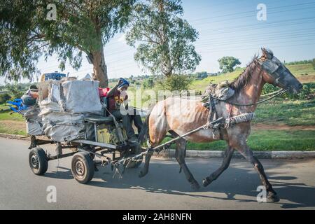 Soweto, Johannesburg, South Africa - December 3, 2019 - a garbage collector rides in a horse drawn carriage to a dump Stock Photo