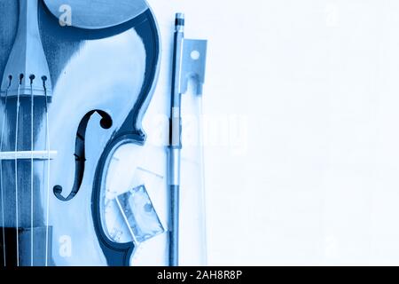Part of the violin, bow and rosin toned in classic blue color. Stock Photo