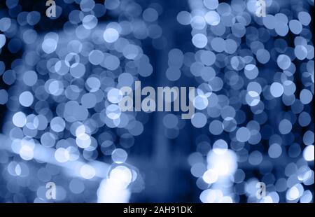 Abstract blurred of red and gold glittering shine bulbs lights background, blur of Christmas wallpaper decorations, toned trendy classic blue color of Stock Photo