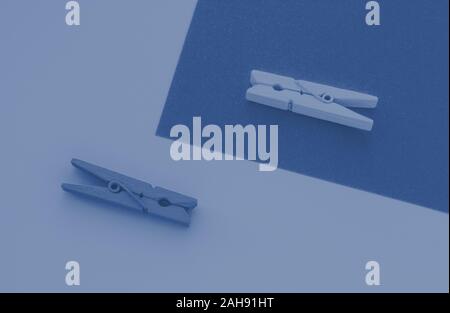 Blue and yellow clothespins on the background, toned trendy classic blue color of year 2020 Stock Photo