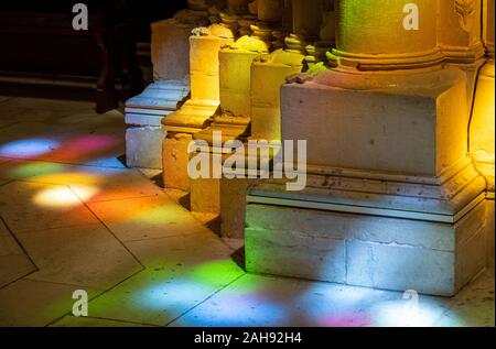 Colored lights from stained glass windows on columns inside the Batalha Monastery near Leiria in Portugal Stock Photo