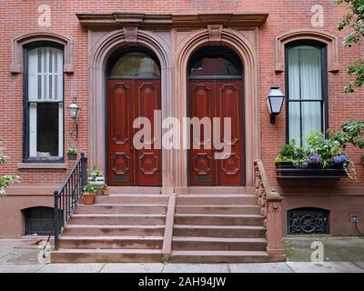 Brownstone style apartments with elegant double wooden mahogany front doors Stock Photo