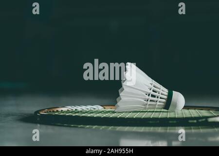 Shuttlecocks and badminton racket on court background. Stock Photo