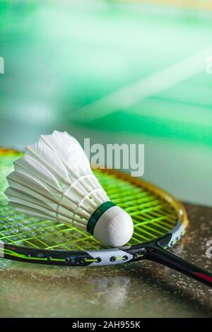 Shuttlecocks and badminton racket on court background. Stock Photo