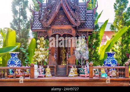 A Thai spirit house, a small replica of a traditional structure, where the deity or spiritual guardian of the property lives and offerings are made. Stock Photo