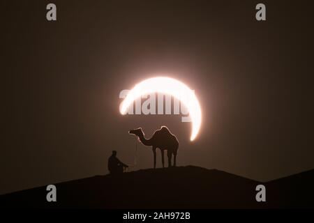 Annular solar eclipse in desert with a silhouette of a dromedary camel. Liwa desert, Abu Dhabi, United Arab Emirates. Stock Photo