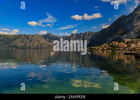 Old stone houses in Kotor Bay or Boka Kotorska and surrounding mountains with crystal clear water in the Balkans, Montenegro on the Adriatic Sea Stock Photo