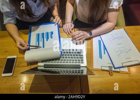 Two businesswomen analyze financial data on document Stock Photo