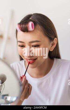 Asian woman beauty blogger,vlogger applying lipstick to her mouth doing cosmetic makeup tutorial Stock Photo
