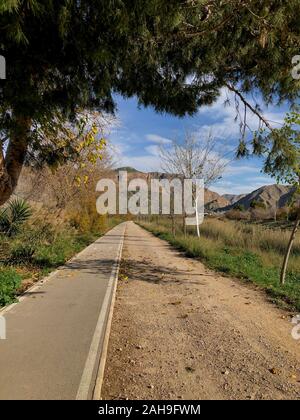 This image shows the riverside outside Orihuela with a hiking/biking trail as it winds toward the mountains in the distance, orihuela city,Alicante Stock Photo