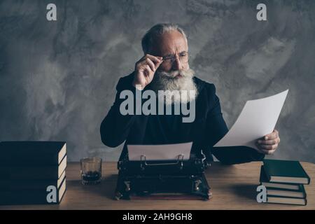 Portrait of his he nice attractive bearded focused concentrated gray-haired professional expert creative publisher reading news life story article Stock Photo