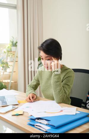 Young Asian businesswoman tired from work in the office Stock Photo