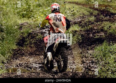 back motocross enduro rider. splashes lumps of dirt Stock Photo