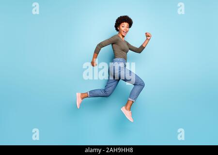 Full length body size photo of cheerful fast quick black woman jumping running towards shopping mall as rapidly as possible wearing jeans denim Stock Photo