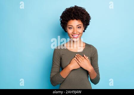 Portrait of positive peaceful calm afro american girl put her hands on chest feel good thankful wear casual lifestyle outfit isolated over blue color Stock Photo