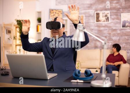 Elderly man experiencing new virtual reality technology for the first time in his home Stock Photo