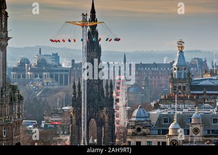EDINBURGH SCOTLAND HIGH FLYING SWINGS OR CAROUSEL WITH BIG WHEEL NEXT TO THE SCOTT MONUMENT IN PRINCES STREET Stock Photo